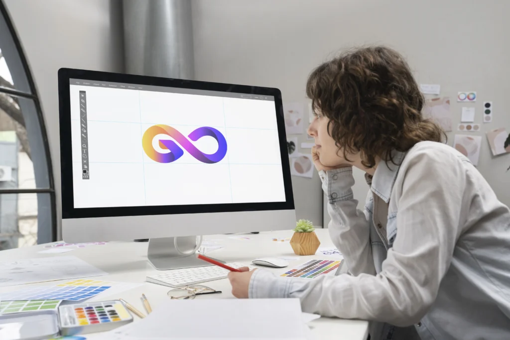 logo designer at a computer reviewing brand assets to decide when to rebrand