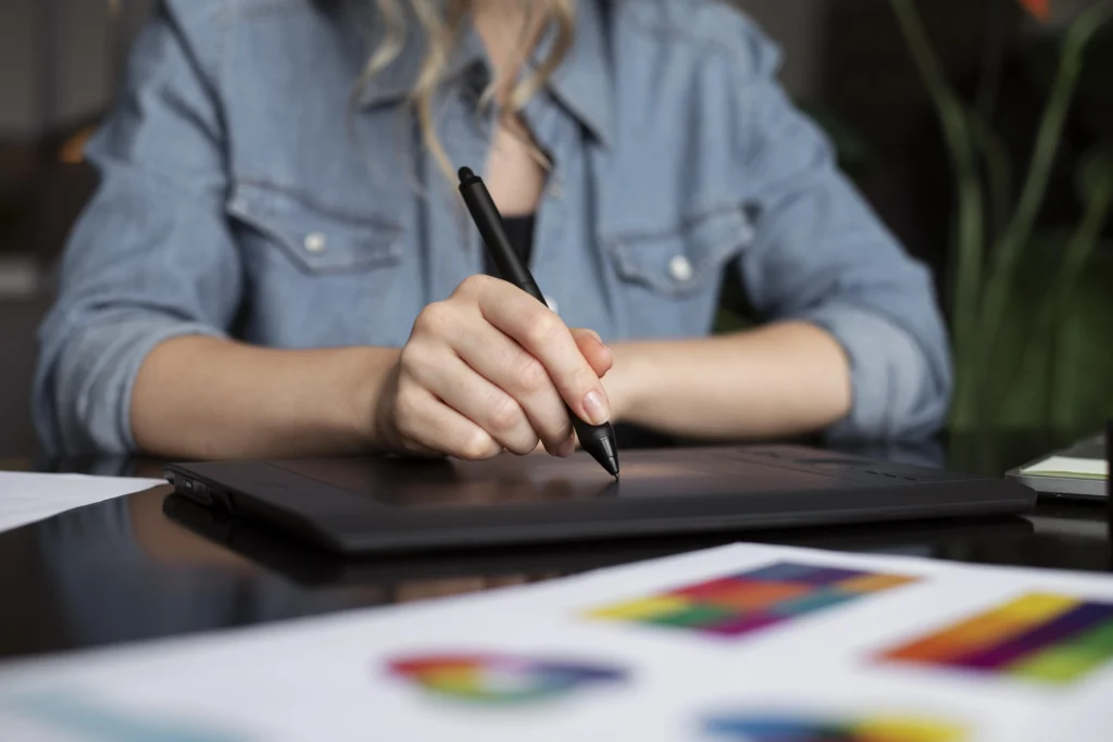 young female logo designer working on a rebrand concept using a graphic tablet